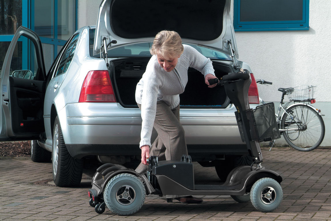 woman stacking mobility scooter into car